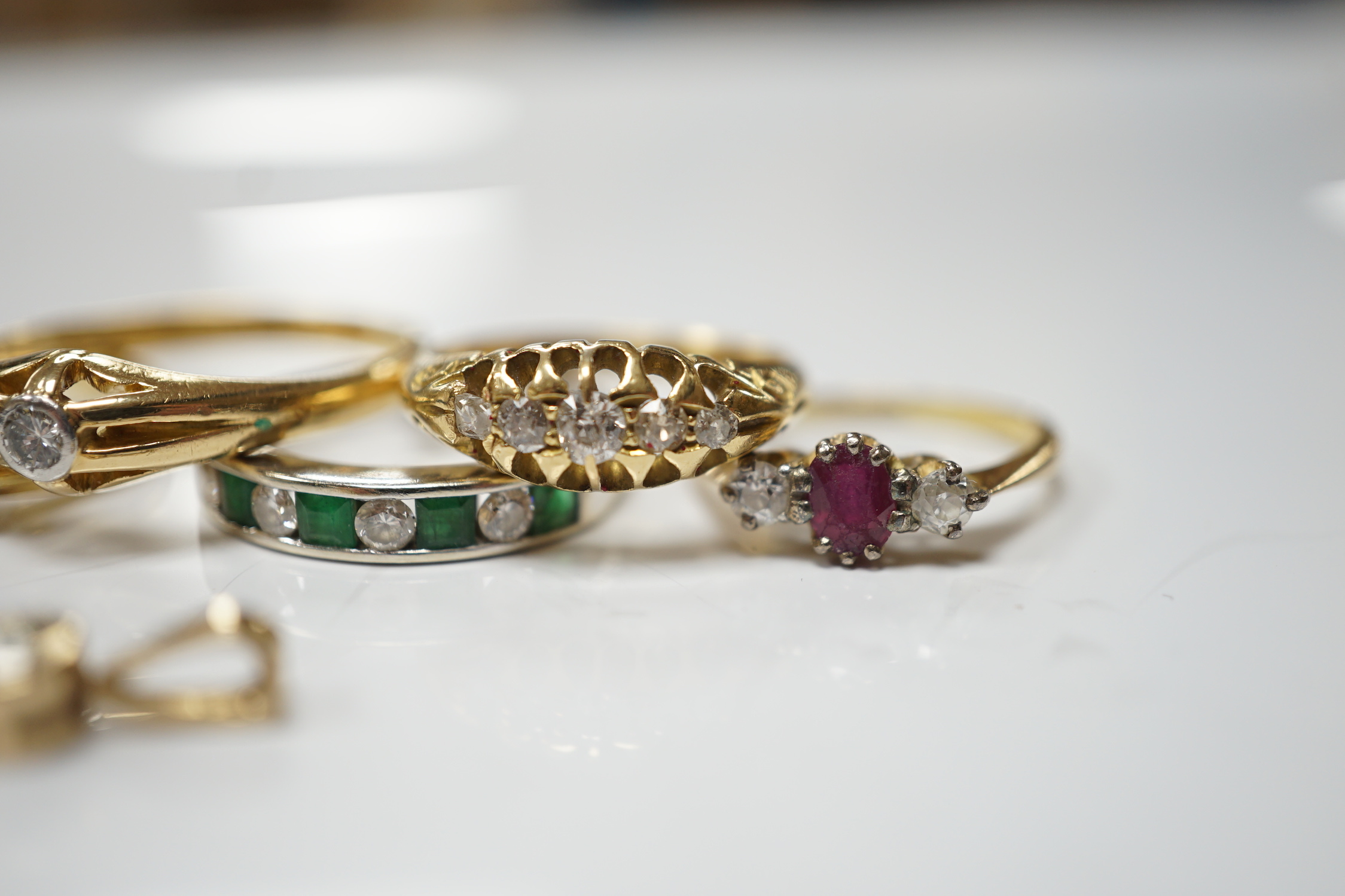 Four assorted early 20th century and later 18ct and gem set rings, including solitaire diamond and three stone diamond, gross 14.6 grams, together with a white metal and channel set emerald and diamond half hoop ring and